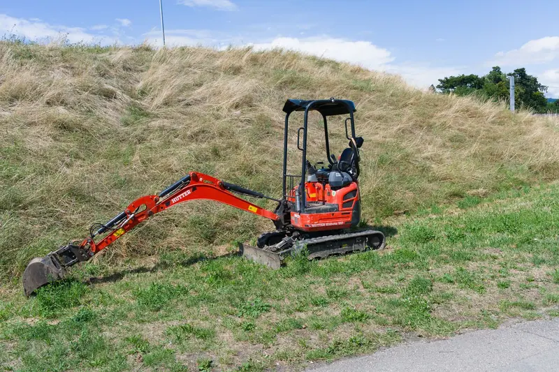 A compact excavator on a grassy slope (representative photo)