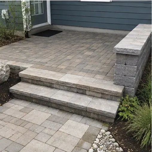 Paver patio with wide steps and a block seat wall